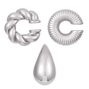 Detailed view of silver C-shaped ear cuffs and textured teardrop stud earring set