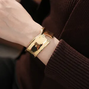 Bracelet jonc ouvert doré irrégulier minimaliste avec surface ondulée sur modèle
