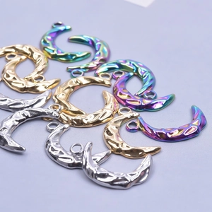 Detailed view of crescent moon charms with hammered texture in gold, silver and rainbow finish