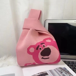 Detailed knit texture of pink Lotso cartoon wristlet bag on white background
