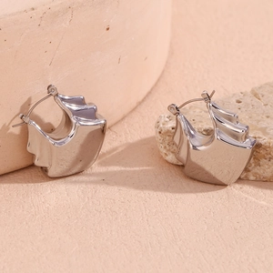 Macro view of silver triple-layered hollow fan-shaped earrings with high-polish finish