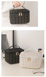 Detail of tweed makeup bag showing gold thread weave and leather handle with metal zipper