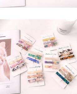 Detailed macro view of colorful acetate hair clips set on elegant marble patterned cards
