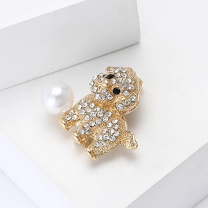 Close-up of a golden dog brooch with sparkling rhinestones and a white faux pearl detail