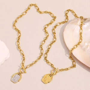 Gold chunky chain necklaces with rectangular moon pendants and toggle clasps on a stone base