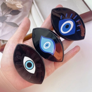 Detailed macro view of three evil eye acetate hair claws with blue eye pattern detail