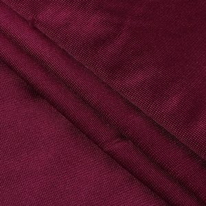 Dettaglio macro del tessuto a maglia bordeaux con pieghe arricciate e trama fluida