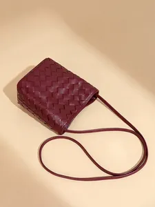 Sac seau bandoulière en cuir tressé bordeaux avec bandoulière réglable style épuré