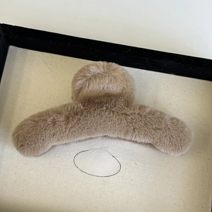 Detailed close-up of a soft plush hair claw clip in a vintage wooden jewelry box