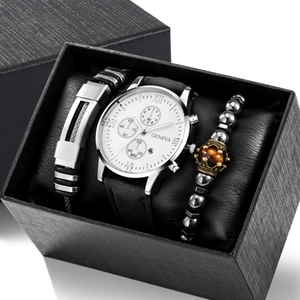 Detail view of silver men's watch with black strap and beaded bracelets in a textured box