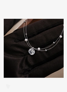 Macro detail of elegant double-layered pearl necklace with sparkling cubic zirconia stone