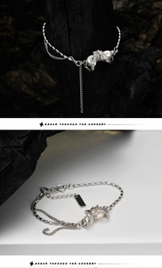 Detail shot of a layered silver bracelet with pearls on a charcoal and white backdrop
