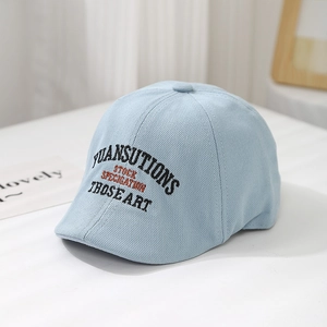 Detailed close-up of light blue knitted newsboy cap with high-quality 3D embroidery textures