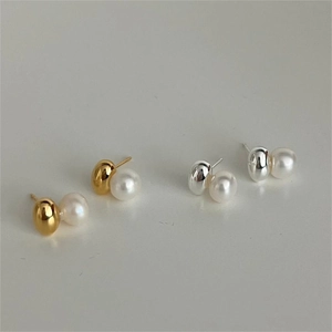 Detailed view of round pearl earrings with smooth gold and silver metal bases