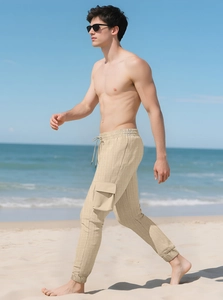Men's sand cargo pants with waffle texture walking on beach with sea background