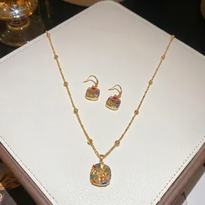 Elegant gold plated jewelry set with multicolor zircon necklace and earrings on white pad