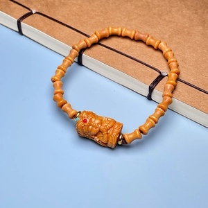Detailed view of carved lotus sandalwood beads resting on a vintage thread-bound book