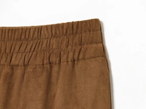 Détail de la taille élastique en daim marron avec coutures renforcées et texture