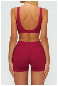 Detail view of burgundy yoga set featuring U-back sports bra and V-seam biker shorts