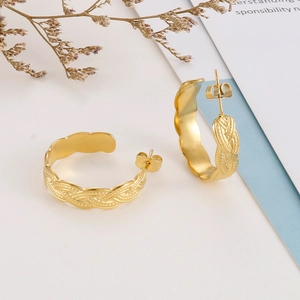 Macro detail of gold plated stainless steel C-shape hoop earrings with woven texture