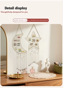 Detailed view of moon and star shaped gold metal mesh jewelry organizers on wall