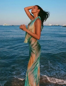 Detail of flowing summer beach dress with abstract green ink print and open back design