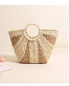 Close-up of woven straw tote bag with gold thread accents and beige striped details