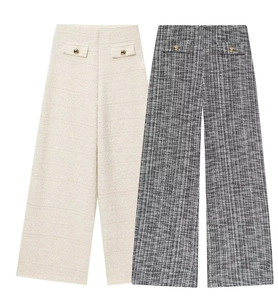 Détail de pantalons en tweed à taille haute beige et gris avec boutons dorés
