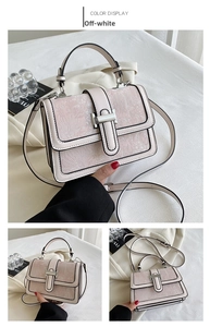 Detail view of beige crossbody bag with floral embossing and silver metallic hardware