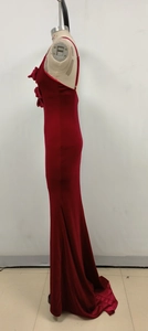 Détail d'une robe de soirée en velours rouge avec roses 3D élégantes et fente latérale