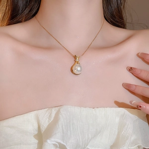 Nahaufnahme der Zirkon-Perlenkette mit goldenem Anhänger am Dekolleté für Damen