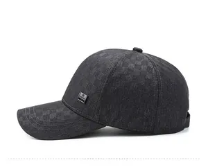 Detail of dark gray baseball cap featuring textured woven fabric and fashion metal badge