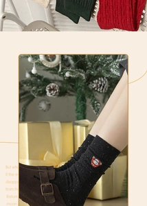 Detail of black cotton Christmas socks with Santa Claus embroidery and cable knit pattern