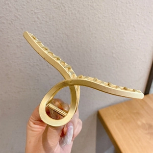 Elegant large golden metal hair claw clip with twisted design for thick hair styling
