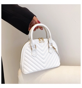 Detail of white PU leather bag featuring V-shaped stitching and gold-tone metal zippers