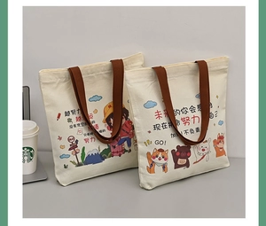 Detail of canvas tote bags with brown handles and cute cartoon character illustrations