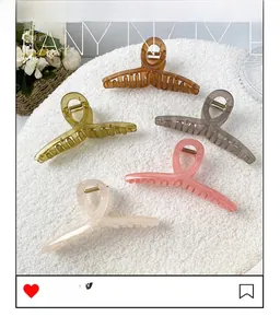 Close-up of five colorful jelly-tone oversized shark hair clips on a soft texture