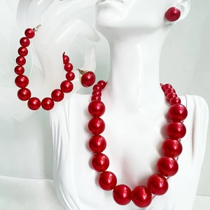 Elegant red pearl jewelry set featuring necklace, bracelet, earrings and ring on mannequin