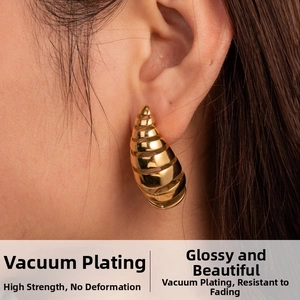Detailed close-up of chunky gold C-shape drop earrings with a polished spiral texture