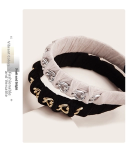 Close-up of vintage metal chains wrapped on pleated fabric headbands in black and beige