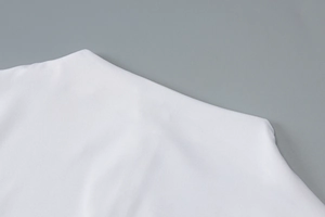 Detail of white premium knit fabric texture and shoulder stitching on sports jumpsuit