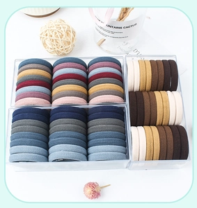 Close-up of assorted colorful velvet hair ties neatly organized in a transparent storage box
