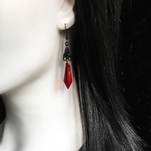 Detailed view of Gothic black bat earrings with red teardrop crystal on a model