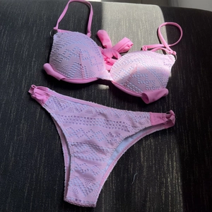 Two-piece pink lace bikini set with halter top and cutout mesh detailing for women