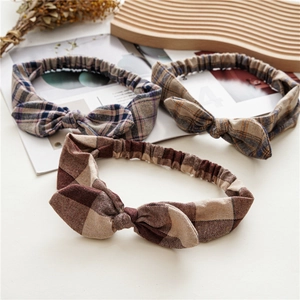 Detailed close-up of plaid knotted headbands in three patterns with elastic back band