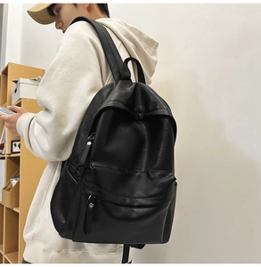 Side view of a black faux leather backpack showing large capacity and smooth texture