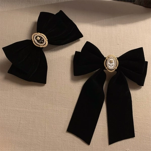 Detail of vintage black velvet hair bows with ornate floral embossed centers