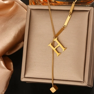 Gedetailleerde macro-opname van goudkleurige titaniumstalen ketting met H-hanger