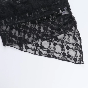 Dettaglio del tessuto in pizzo nero con trama semitrasparente e ricami intricati