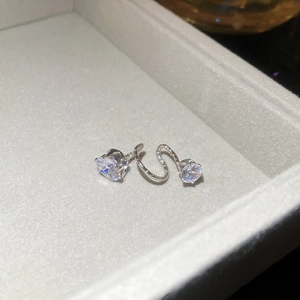 Detail of silver S-shaped jewelry set with sparkling faceted zircon in a soft gray box